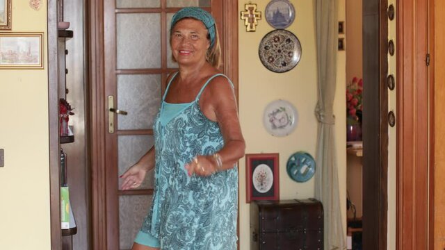Video in 4k di donna anziana che si diverte a ballare a casa sua in un ballo spensierato