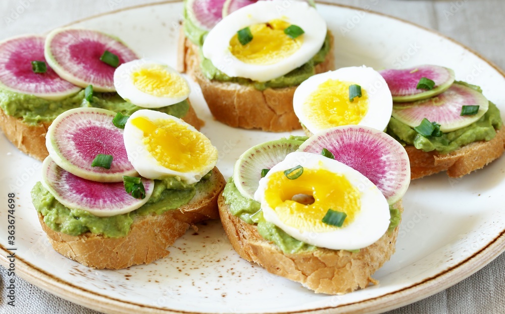 Poster watermelon radish sandwich with avocado and egg. healthy balanced breakfast. bright toast