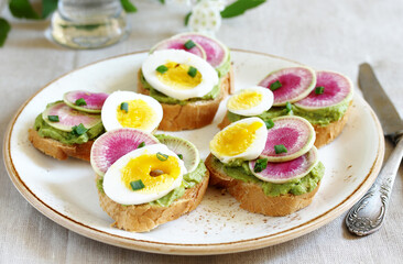 watermelon radish sandwich with avocado and egg. healthy balanced breakfast. bright toast