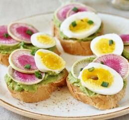 watermelon radish sandwich with avocado and egg. healthy balanced breakfast. bright toast