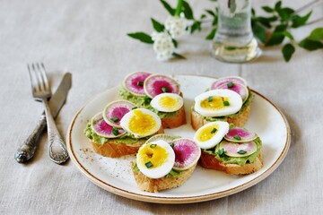 watermelon radish sandwich with avocado and egg. healthy balanced breakfast. bright toast