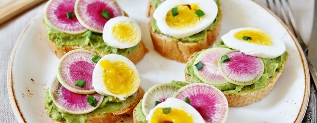 watermelon radish sandwich with avocado and egg. healthy balanced breakfast. bright toast