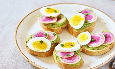watermelon radish sandwich with avocado and egg. healthy balanced breakfast. bright toast