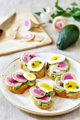 watermelon radish sandwich with avocado and egg. healthy balanced breakfast. bright toast