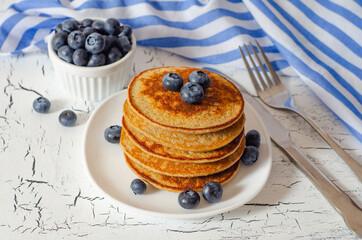 Pancakes with blueberries on white table. Healthy breakfast. Blueberries, raspberries on pancakes.