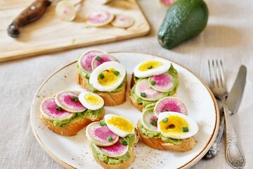 watermelon radish sandwich with avocado and egg. healthy balanced breakfast. bright toast