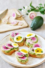 watermelon radish sandwich with avocado and egg. healthy balanced breakfast. bright toast