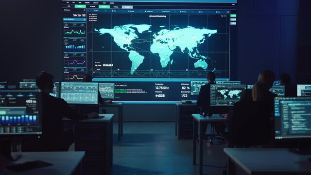 Team of Professional Computer Data Science Engineers Work on Desktops with Screens Showing Charts, Graphs, Infographics, Technical Neural Network Data and Statistics. Dark Control and Monitoring Room.