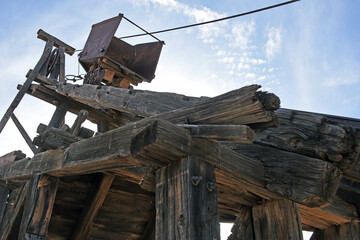 Looking up at an old mining cart on a wooden headframe in Vulture City, Arizona