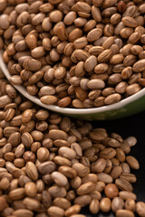 Carioquinha type beans over black background. Brazilian beans. Top view