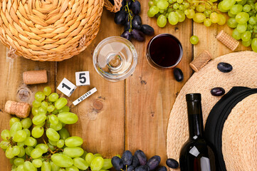  Traditional Italian holiday and summer holidays, August 15 on a cube calendar. Fragosto harvest festival. Red and white wine on a wooden background and grapes. Copy space. Flat lay