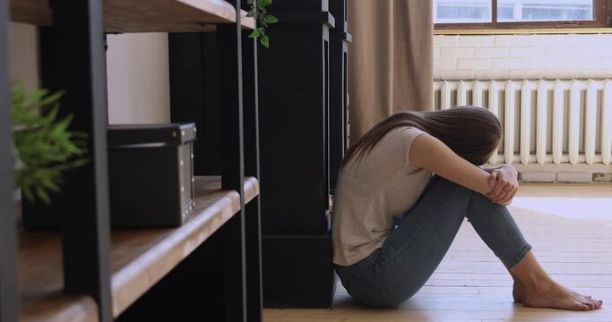 Depressed sad teen girl sit on floor crying alone at home, upset insecure vulnerable young woman feeling frustrated powerless anxious suffer from unwanted pregnancy problem, grief, loneliness concept