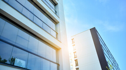 Fototapeta na wymiar Modern apartment buildings on a sunny day with a blue sky. Facade of a modern apartment building. Glass surface with sunlight.