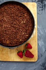 Chocolate cake is decorated with strawberry berries. Homemade cake. Pie on a grey background