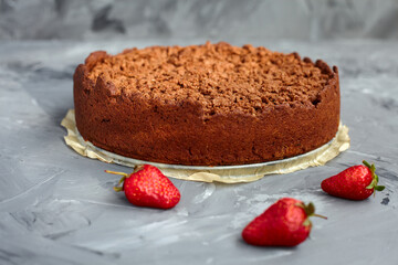 Chocolate cake is decorated with strawberry berries. Homemade cake. Pie on a grey background