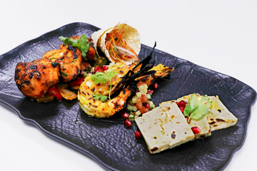 .tandoori platter with chicken tikka, grilled prawns, and paneer along with dal makhani, wheat...