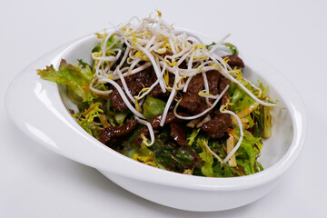 Thai beef salad with crunchy vegetables and mixed lettuce leaves.