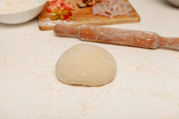 Fototapeta na wymiar Preparation of the dough for pizza. Hands prepare the dough