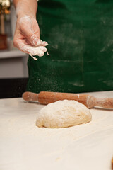 Preparation of the dough for pizza. Hands prepare the dough