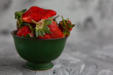 Ripe red strawberries. Bowl filled with juicy fresh ripe red strawberries. strawberries on a grey concrete table. Fresh strawberries photo. Сoncept healthy food