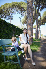 family sitting on bench in park 