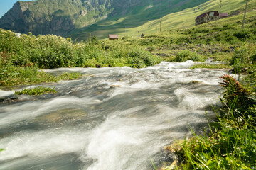 Naklejka na ściany i meble Water in mountain river from glacier on valley. Beautiful landscape Caucasus
