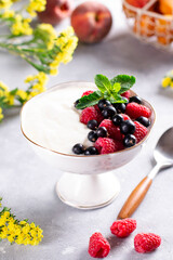 Bowl of fresh mixed berries and yogurt with farm fresh raspberries, blackberries and mint