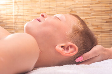 the osteopath makes craniosacral therapy to the child