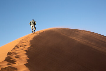 Hombre andando por la duna 45 en el desierto de Sossusvlei, Namibia. 