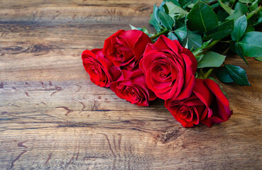 natural red rose in a bouquet on a wooden background