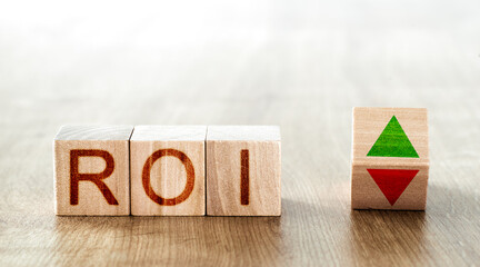 roi concept. wooden blocks with roi inscription and block with up and down arrows
