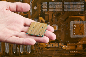technician person holds cpu central processor unit over circuit board background. hardware research...