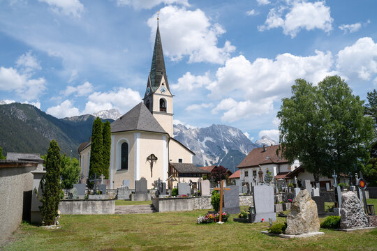 Traditional Austrian village church and cemetery in the alpine mountains, Obsteig, Tirol, Austria