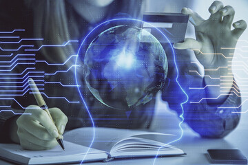 Double exposure of woman on-line shopping holding a credit card and brain hologram drawing. Data...