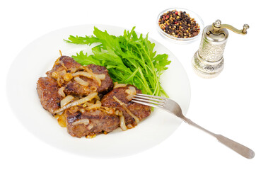Pieces of fried liver with onions, fresh leaves of salads