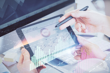 Double exposure of man's hands holding and using a phone and financial chart drawing. Market analysis concept.