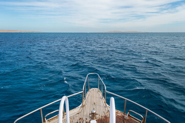 Bow of yacht on seascape background. View from yacht bow to sea horizon. Blue waves of Red sea. Way...