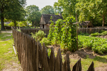Naklejka premium A garden with a rustic building in Historic Yorktown village, part of Colonial National Historic Park, Virginia, established by the Act for Ports of 1691
