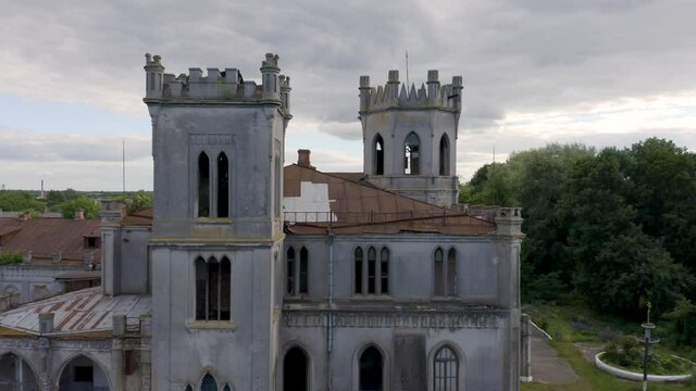 Abandoned 19th century palace  (manor or mansion house) with broken windows in Neo-Gothic (Gothic Revival) style. Aerial side view.