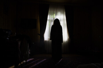Horror woman in window wood hand hold cage scary scene halloween concept Blurred silhouette of...