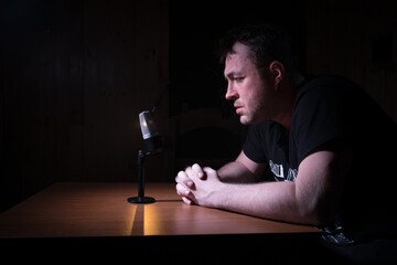 Serious reporter in television studio looking at the camera