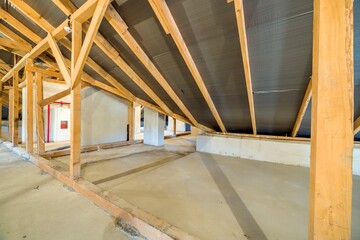 Attic of a building with wooden beams of a roof structure.