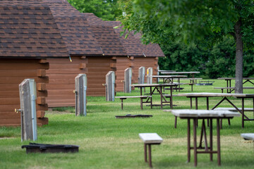 Rows of rustic camping cabins, with water pumps and picnic tables at a campground