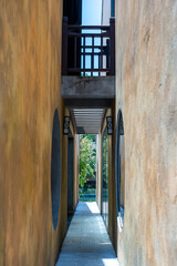 Tiny alley with old yellow painted walls on both sides in Da Nang, Vietnam