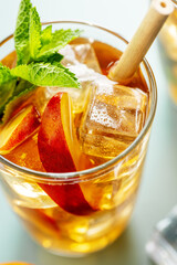Iced tea with peach and ice cubes