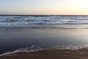 Sunset with rough sea on the beach