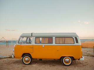 Vintage busje op het strand tegen de lucht tijdens zonsondergang