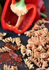 raw fusilli paprika pasta, close-up on a black background. homemade pasta without dyes from durum wheat.   