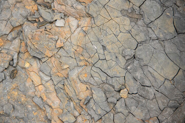 Red grunge background. Rock texture with cracks. Red brown yellow mountain texture closeup. Cracked stone surface. Natural stone background