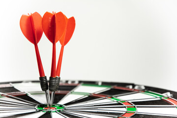 Success hitting target aim goal achievement concept background - three darts in bull's eye close up